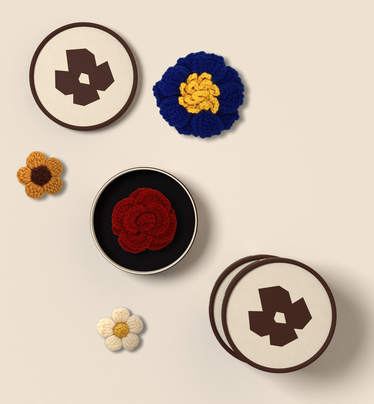 Trois écrins LEZARE vus de dessus, l’un ouvert sur une fleur en crochet, fleurs posées autour